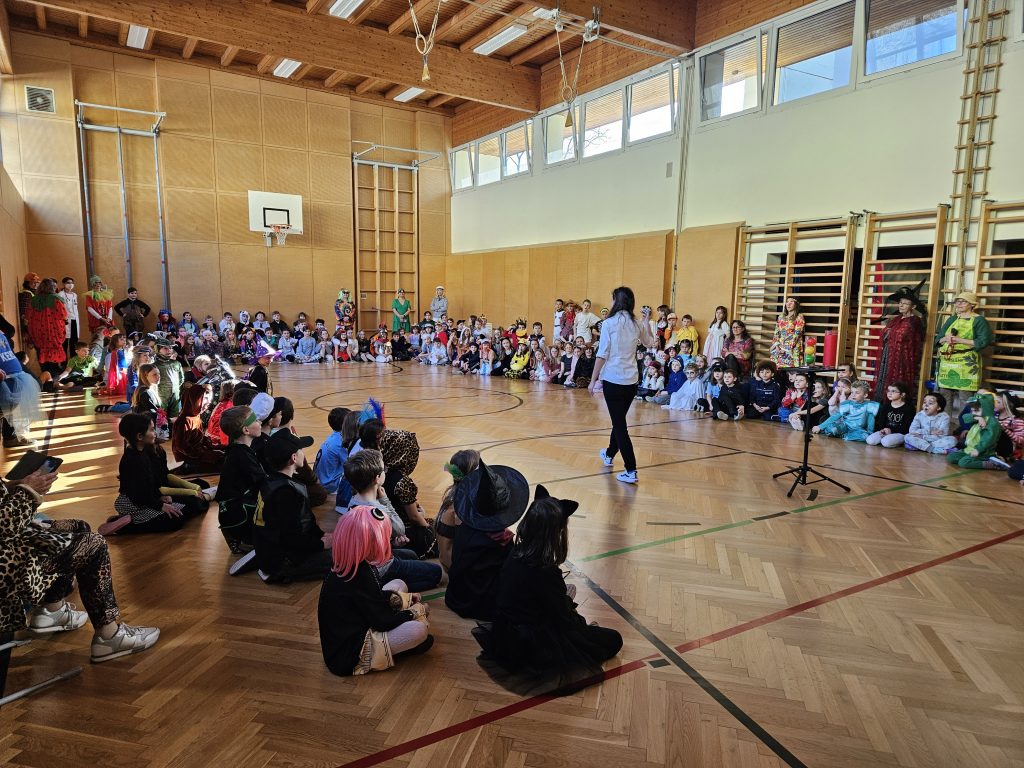 Schülerinnen und Schüler verfolgen die Zaubershow in der Turnhalle