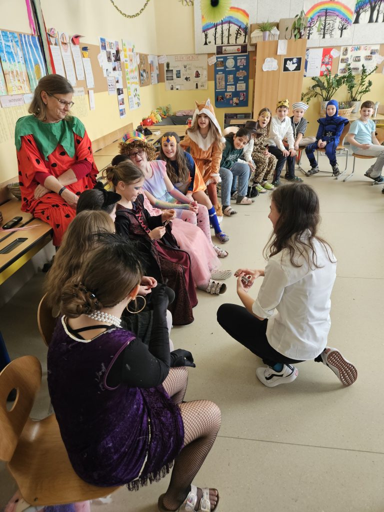 Diana zaubert beim Faschingsfest mit Kindern in Kostümen